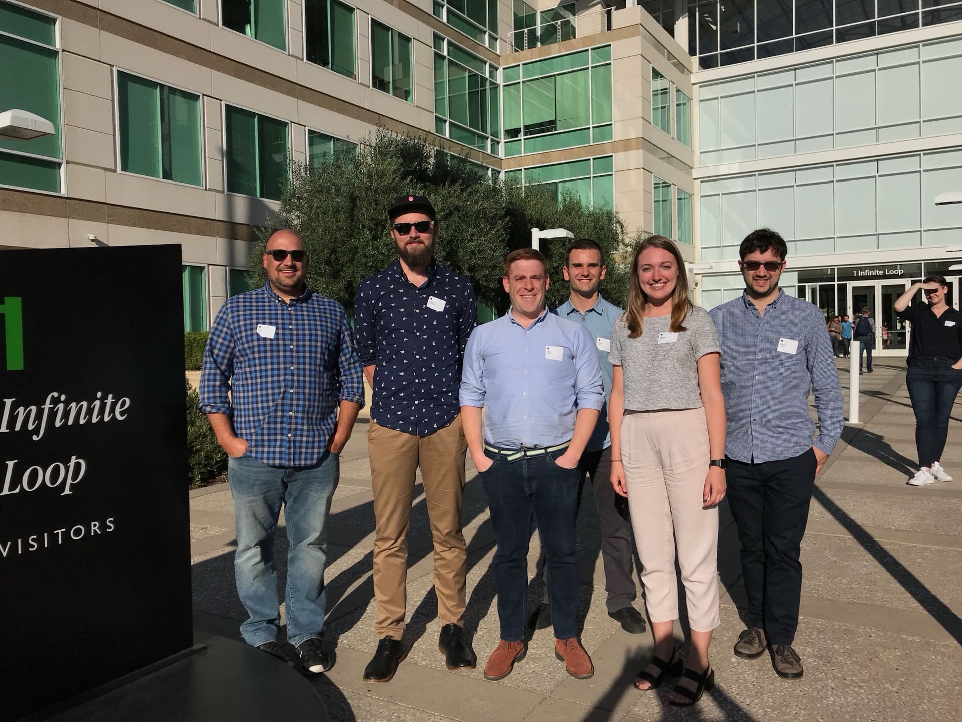 The init.ai team outside 1 Infinite Loop, visitor badges on